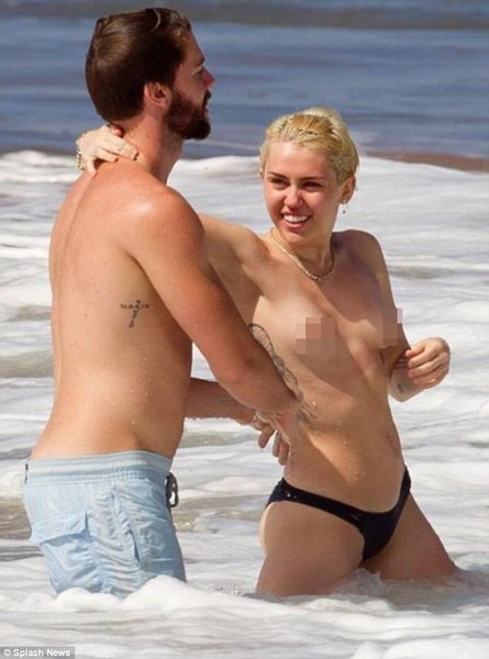 Miley Cyrus topless in the ocean with boyfriend Patrick Schwarzenegger 